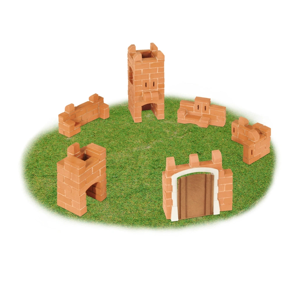 Teifoc castle set features orange bricks arranged in a circular pattern on a green surface, resembling a castle structure.