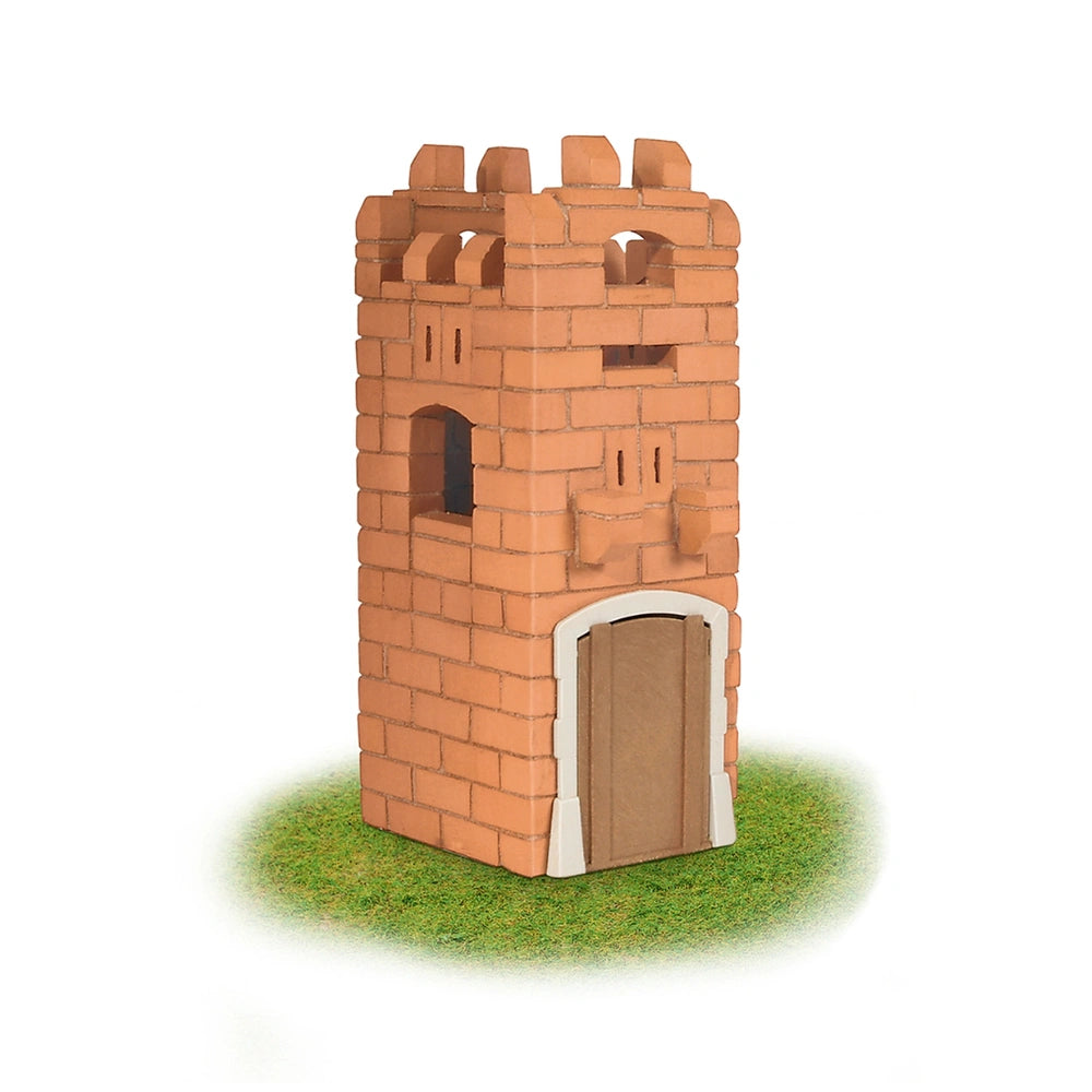 Teifoc castle model made of brick-like material, featuring a door and windows, placed on a green grass-like surface.