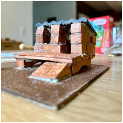 Teifoc chicken coop model crafted from reddish-brown material, centered on a light brown wooden surface.