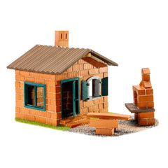 Teifoc house model features red brick walls, green windows and door, and a brown shingled roof on a grassy surface.