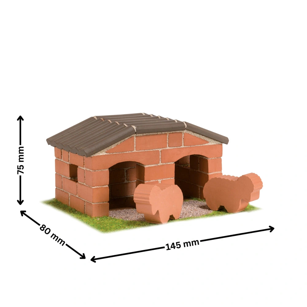 Teifoc sheepfold model features a red brick structure with a brown roof, set on a green lawn with two small figures in front.