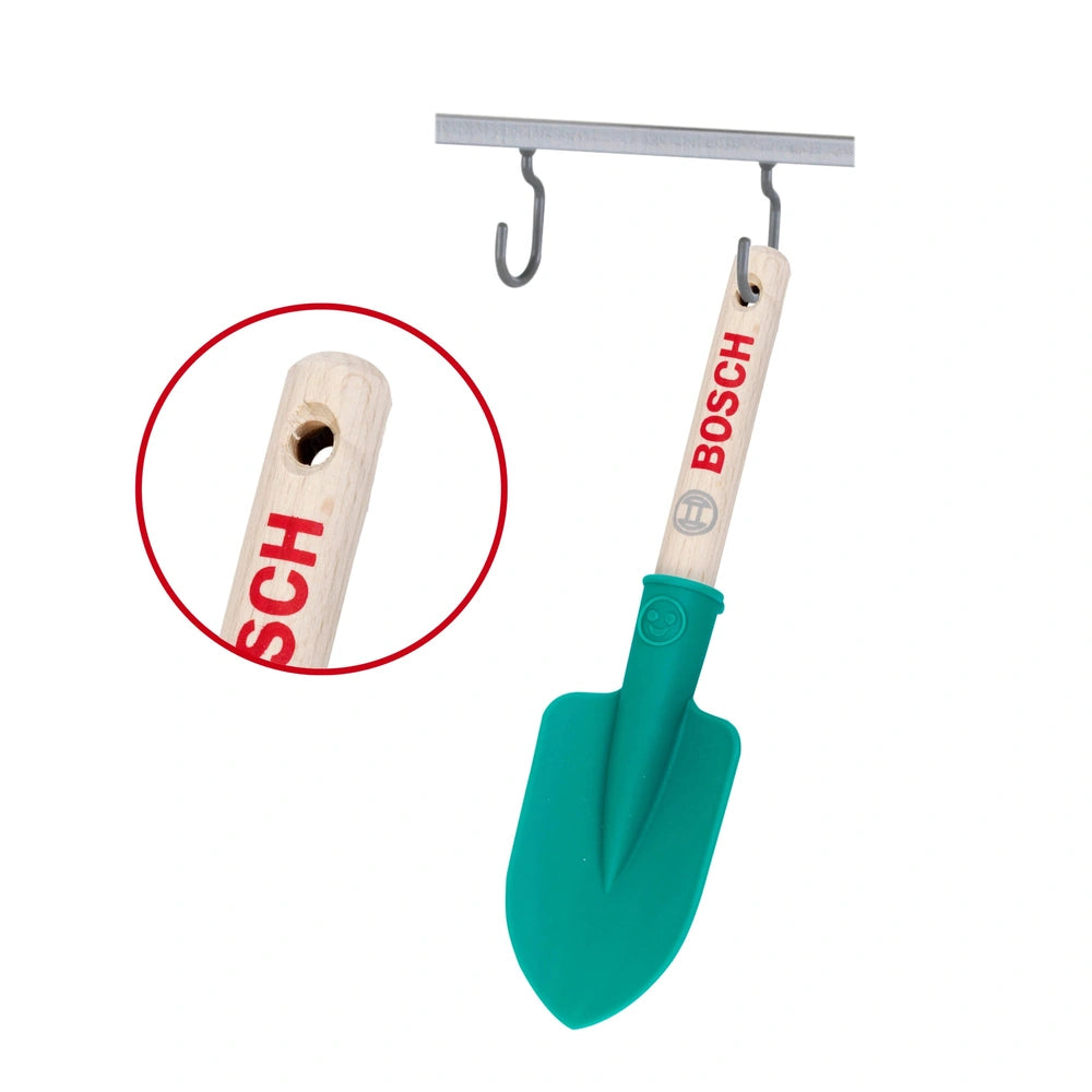 Theo Klein Bosch garden hand shovel with green plastic blade, brown wooden handle, and silver metal hook and clamp.