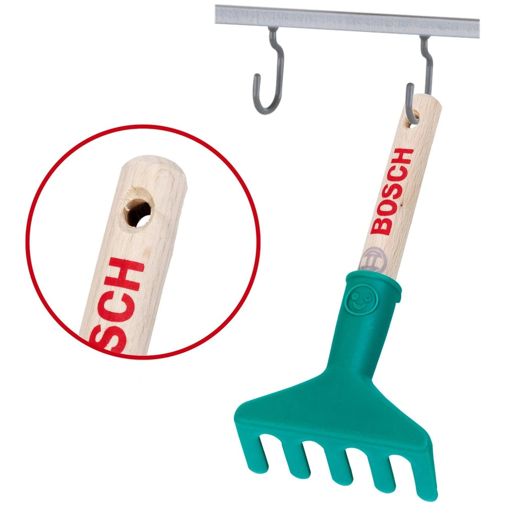Theo Klein Bosch Garten hand rake with a wooden handle, green plastic head, and metal hooks, featuring "SCH" and "BOSCH" text