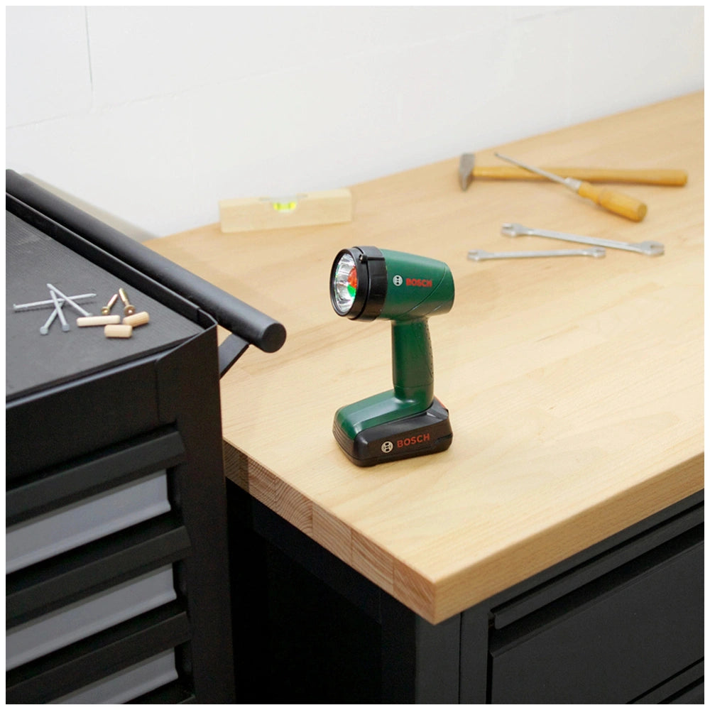Theo Klein Bosch power tool set on a wooden table featuring green and black tools with metal components and printed specifica