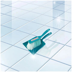 Theo Klein Leifheit sweeping set featuring a blue-handled brush with white bristles on a smooth light-colored tile floor.