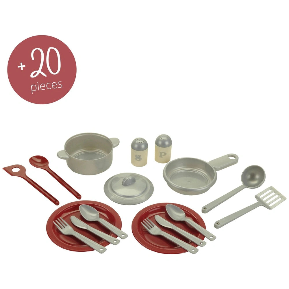 Theo Klein Miele Kitchen Compact set featuring shiny metal utensils and red plastic bowls and plates, arranged centrally.